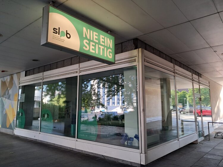 Ein Schaufenster der Landeszentrale für Politische Bildung mit dem grünen Wappen lpb und Werbematerialien.