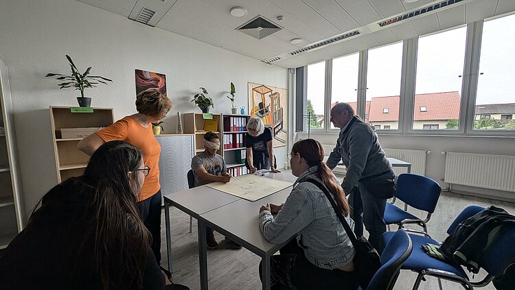 Rückblick Sportfest 2024 Koordination. Ein Teilnehmer bekommt die Augen verbunden muss mit einem Stift gewissen Formen und Bilder frei Hand malen.