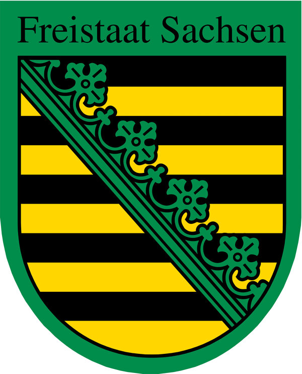 Wappen des Freistaats Sachsen: Ein gelb-schwarz gestreifter Schild mit grünem Rautenband und grünen Blättern, umrahmt von einem grünen Rand. Oben steht „Freistaat Sachsen“.