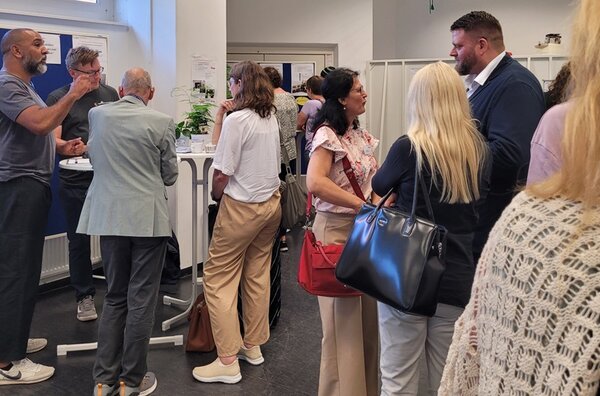 Die Teilnehmenden des Reinickendorfer Ausbildungsdialogs tauschen sich rege aus, an Stehtischen.