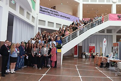 Gruppenfoto der zahlreichen Teilnehmenden an der Jobmesse für Mütter stehen auf einer langen und breiten Treppe hintereinander.