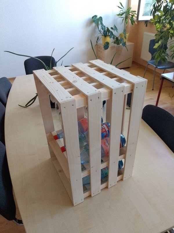 Rückansicht des stabilen Holzregals mit verschraubten Leisten, eingelegten Getränkeflaschen und sichtbaren Gläsern im Inneren.