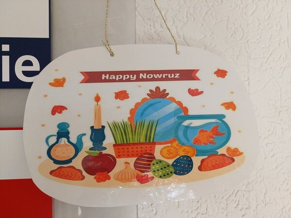 Selbst gestalteter, bunter Anhänger mit mit Schriftzug Happy Nowruz.