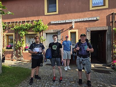 Pilgern mit Perspektive Die vier männlichen Auszubildenden zu Fachlageristen posieren nach erfolgreicher Pilgerwanderung gut gelaunt vor dem Wal- und Wüstenberghaus.