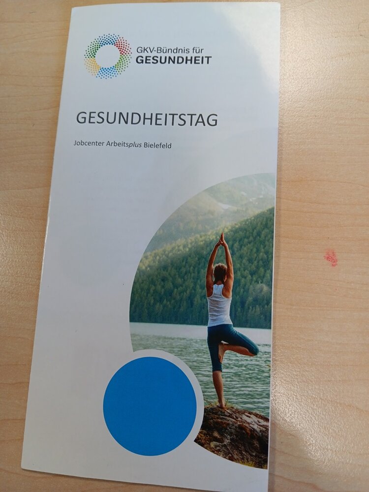 Informationsflyer Gesundheitstag des Jobcenters Arbeitsplus Bielefeld, mit Titelbild einer Yoga praktizierenden Frau in der Natur. 