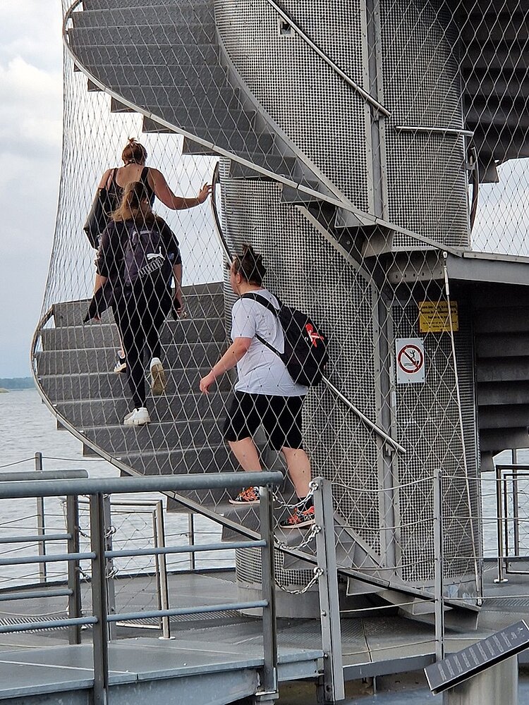 Abschlussfeier der Azubis Die Auszubildenden steigen hintereinander auf den hohen Pegelturm.