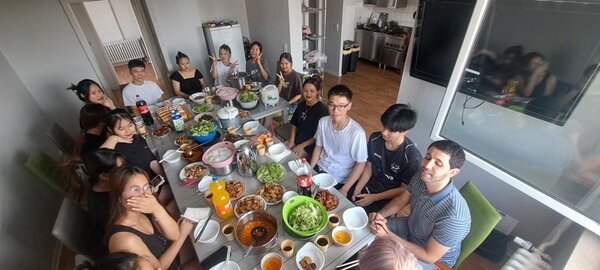 Die Teilnehmenden sitzen an der gedeckte Tafel mit vielen, selbst zubereiteten vietnamesischen Gerichten.