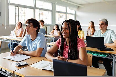Verschiedene junge Schüler, die Lehrer im Klassenzimmer zuhören.