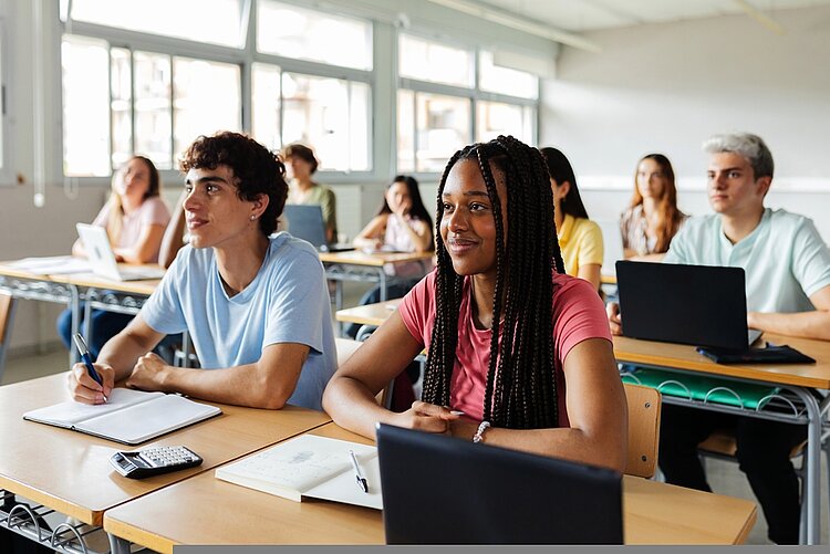 Verschiedene junge Schüler, die Lehrer im Klassenzimmer zuhören.
