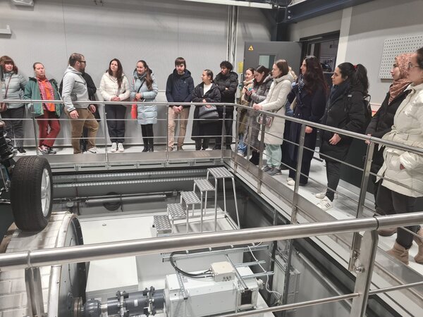 Die Schülerinnen und Schüler stehen um ein Auto herum und schauen bei Tests zu.