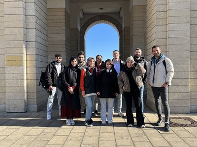 Teilnehmende des Orientierungskurses posieren vor der St. Stephan Kirche in Mainz für ein Foto.